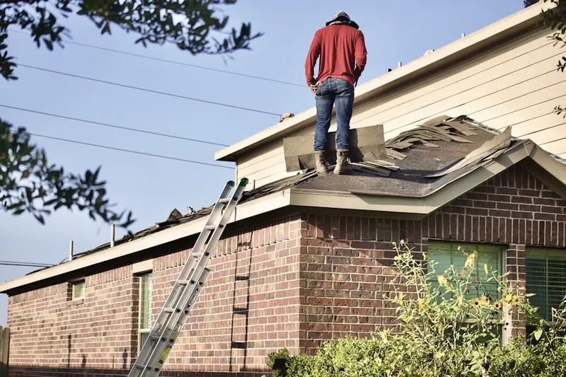 Professional roofer working on a residential roof in North Main Area